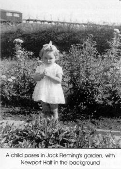 A child poses in Jack Flemings garden, with Newport Halt in the background.