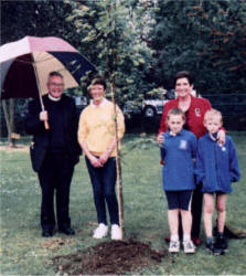 Mrs Dorothy Weir plants a tree to commemorate her late father, a past pupil of Hillhall Primary School. Included in the photo are Rev Dr Jack Richardson MBE, Mrs Angela Moore (Principal) and pupils Kathryn Reid and Jordan Owens.