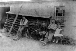 fig. 2 : Samuel Dugan. (1859-1910) outside his blacksmith's shop on the Blllyskeagh Road, just beyond  just beyond the parochial hall. His family, are from left to right, Robert, George, Hill and Sadie. The photograph was taken c. 1905.