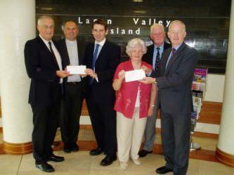 Lisburn City Centre Ministers are pictured presenting proceeds from the 2003 “Carols In The City” concert to representatives from Thompson House and Tear Fund. 