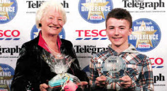 Adam is presented with his award by Dame Mary Peters