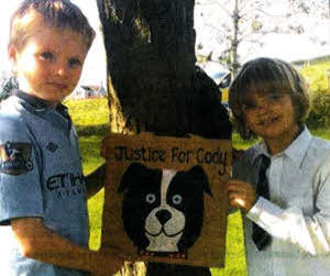 The Agnew brothers Justin and Jake with a bag made by Karen Houston in memory of their beloved pet dog Codie who had to be put to sleep following horrific injuries after being set alight.