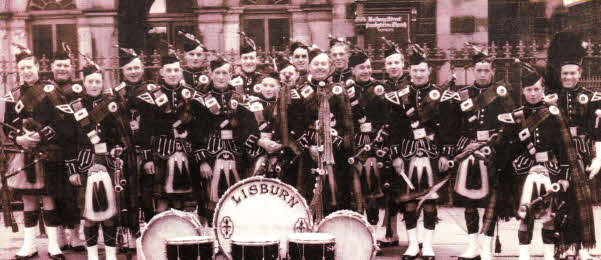 This photograph belongs to Stanley Wilson a former member of the Lisburn Pipe Band. He thought it would help stir up a few memories. Stanley thinks the photo was taken around 1950 and it was outside Railway Presbyterian Church.The people he can remember in the photo are as follows: Front row: Gerald Best, unknown, Maurice Lockhard, B McNeilll„Angus McClune, Enver McKay, Jim Adams and a Mr Millar. Centre row: Malcolm Crangle, George Forbes, John Mines, David Friars, Jimmy Wars. Back row: Dick Maze, Jimmy Reilly, Stanley Wilson and Jonnie Ringland.