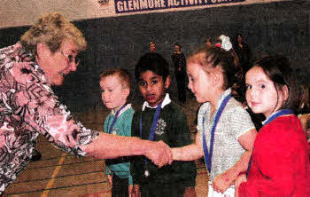 Representing the Integrated Education Fund (IEF), Geraldine Tigchelaar the former Principal of Forthill Integrated College presents medals and certificates to children from Pond Park Nursery School and St Aloysius Nursery Unit to mark the completion of their cross-community project funded by the IEF PACT (Promoting a Culture of Trust) scheme.