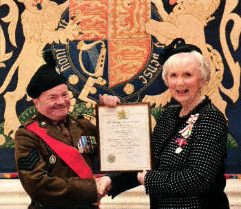 Sergeant Instructor Titch Hughes receiving his Lord Lieutenant's Certificate from Mrs Joan Christie, Her Majesty's Lord Lieutenant for the County of Antrim.