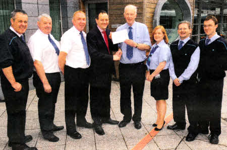 William Thompson receiving a retirement gift from Translink Service Delivery Manager Jim McCauley. Looking on are Inspectors - Martin McKeown, Robin Mackin and Michael Stewart (left) and Clerks - Klm Stewart and Graham Catney and Gerard McKavanagh, Parcel Messenger (right).
