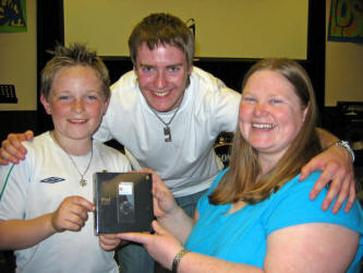 Thomas McCormick (left) is pictured receiving an iPod, which he won in a competition ran by Debbie Boyce (right) and Jonny Mills at �Lost� in the Lisburn City Centre Elim on Friday 2nd May.
