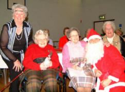 L to R (seated) Lady Sylvia McConnell, Jennie Wales and Molly Johnston are pictured after receiving a gift from Santa (Ian Barron) and Santa�s helper (Norma Coggins) at the Senior Members� Christmas Tea in Railway Street Presbyterian Church on Saturday 2nd December.