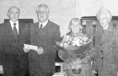 Mr. Harold Kerr (left) and Miss Maureen Skelly (right) of Dromara Reformed Presbyterian Church present gifts to the Rev. and Mrs. Hawthorne as they prepare to depart for Dervock. BL17-506