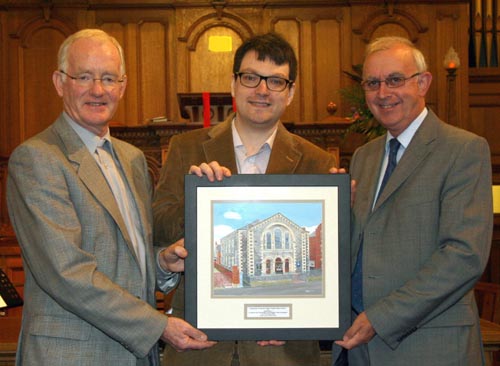 Local artist Jason Kelly presents his painting of Railway Street Presbyterian Church to the Rev Brian Gibson and Mr Gordon Lindsay