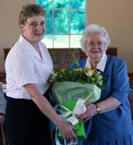 Mary McBride presents a bouquet of flowers to Vance Addis in recognition of 50 years service to St Andrew's. Vance was the first female warden of the church.