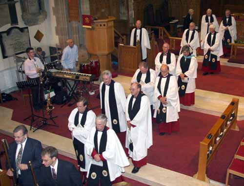 Church wardens - John Humes and Graeme Clarke, lead the Lisburn Cathedral Chapter of St Saviour out of the historic building during the recessional hymn.