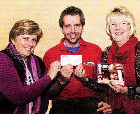 Roger Gowdy on behalf of the African charity Abaana receives a cheque from Margaret Artt (left) and Carolyn Gowdy (right).