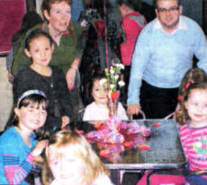 Children from Maghaberry Elim's Detonate junior youth club and Jam Sunday School prepare for their Valentine candle-lit supper in the church hall as Sunday School Superintendent Mrs Freya Gilmore and Detonate worker Mr Darren Brown look on.