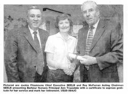 Pictured are Jackie Fitzsimons Chief Executive SEELB and Roy McFerran Acting Chairman SEELB presenting Barbour Nursery Principal Ann Truesdale with a certificate to express gratitude for her service and mark her retirement. US25-564JC