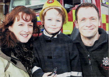 Evie McGale, aged four, who helped prevent a house fire, with Tracey Cassells, principal of Barbour Nursery School, and Kent Smith, firefighter. US4608-549CD
