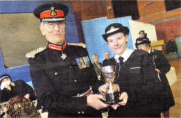 Jennifer McKendrick from the Lisburn Q Division of St. John Ambulance collects the Neill Cup on behalf of the division for the Cadet Proficiency Scheme from special guest Her Majesty's Lord Lieutenant for County Down Colonel William Hall at the recent trophy presentation at the St. John Ambulance Annual First Aid and Care Competitions. 