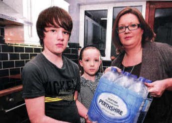 Melanie Menary and children Peter and Lauren, were without mains water for eight days and had to rely on bottled supplies over the Christmas period. US0111-518cd Picture: Cliff Donaldson