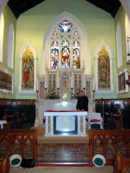 The Very Rev. Desmond Loughran pictured at the Church of St. Michael’s, Finnis, Dromara. The Archangels, Michael, (left) and Raphael keep vigil in the sanctuary of St. Michael’s, Finnis, today.