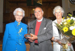 Mrs Vivienne Weir, a Senior Elder and life long friend of the Cromie family, is pictured presenting gifts to The Very Reverend Dr Howard Cromie and his wife Kathleen.